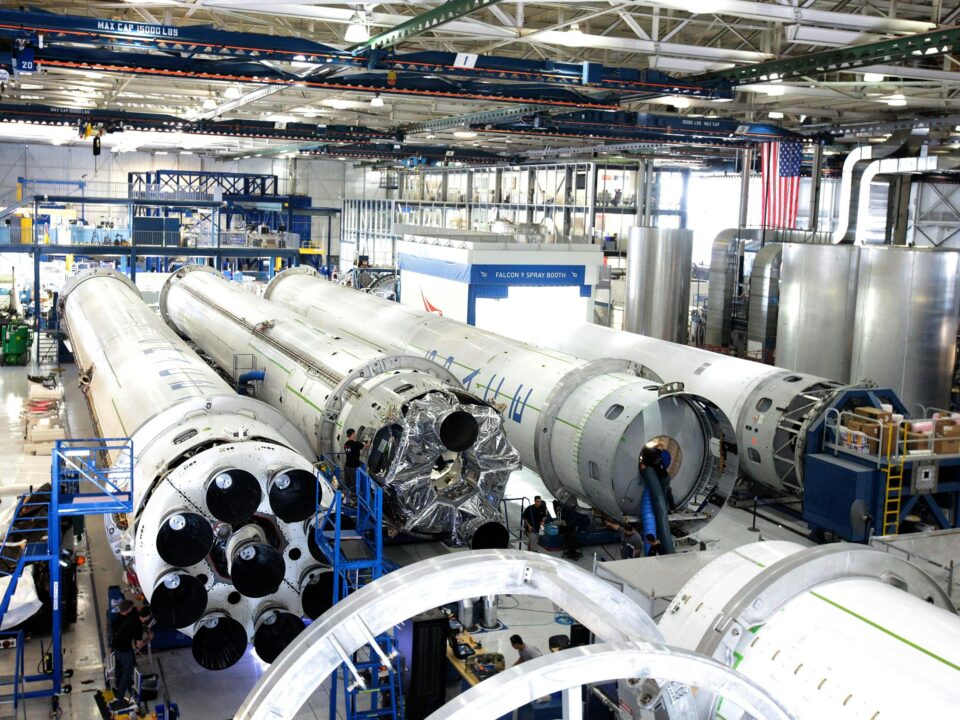 View of a spacecraft assembly line with rockets in a spacious hangar.